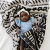 Adorable baby girl laying on super cozy and soft Mudcloth DOUBLE-LAYER BAMBONI RECEIVING BLANKETS - Saranoni