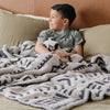 Little boy snuggling in bed with extra thick and soft Mudcloth DOUBLE-LAYER BAMBONI THROW BLANKETS - Saranoni