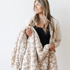 Woman holding on to extra thick and soft Tan Leopard DOUBLE-LAYER BAMBONI THROW BLANKETS - Saranoni