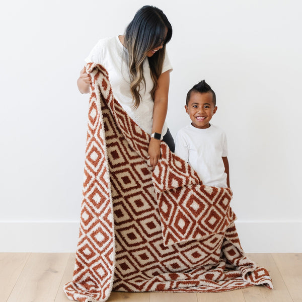 Mom and son holding on to beautiful, double-sided Khmer DOUBLE-LAYER BAMBONI THROW BLANKETS - Saranoni