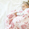 Little girl falling asleep in bed with super soft and comfy Pink Petal DOUBLE-LAYER BAMBONI TODDLER BLANKETS - Saranoni