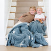 Two boys playing on the stairs, sitting with beautiful and soft Blue + White Stars Nightfall DOUBLE-LAYER BAMBONI TODDLER BLANKETS - Saranoni