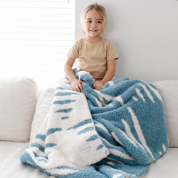 Little kid sitting with super cozy and beautiful Blue + White Stripe Triangle DOUBLE-LAYER BAMBONI TODDLER BLANKETS - Saranoni