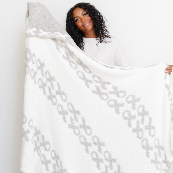 Woman showing both sides to the beautiful HOPE DOUBLE-LAYER BAMBONI® XL BLANKETS - Saranoni