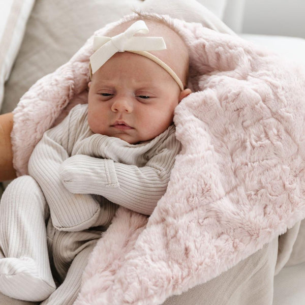 Baby falling asleep in blush pink DREAM MINI BLANKETS - Saranoni