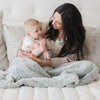 Mom and baby boy sitting with heather blue DREAM RECEIVING BLANKETS - Saranoni