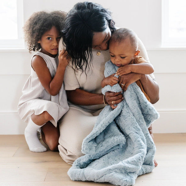 Family snuggling with cozy DREAM RECEIVING BLANKETS - Saranoni