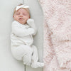 Baby laying beside blush pink DREAM RECEIVING BLANKETS - Saranoni