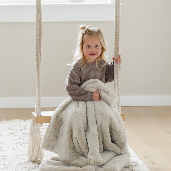 Girl on swing holding DREAM TODDLER BLANKETS - Saranoni