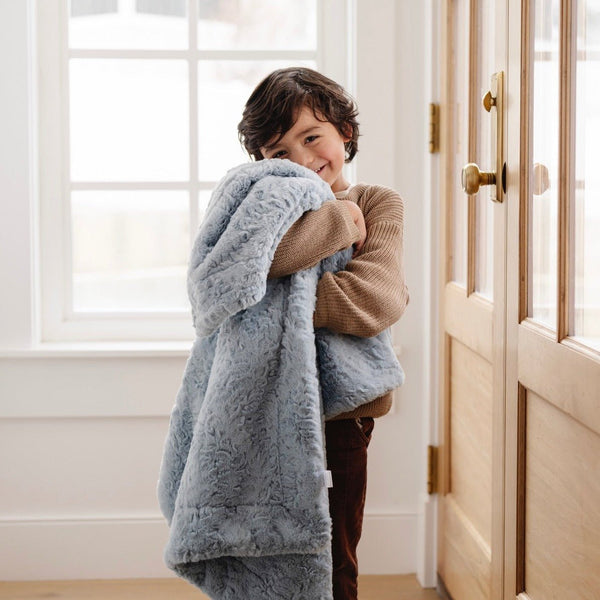 Boy smiling with heather blue DREAM TODDLER BLANKETS - Saranoni