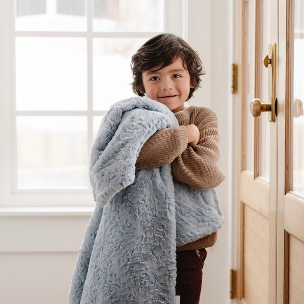 Boy holding his favorite heather blue DREAM TODDLER BLANKETS - Saranoni