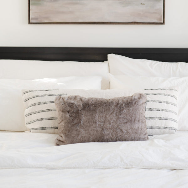 Dense and breathable Saranoni Grand pillow cover on a bed with big fluffy blankets