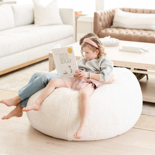 Young readers comfortably seated on a Saranoni Bean Bag, enjoying a quiet moment.