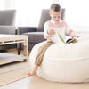 Kid reading on a large Saranoni Bean Bag, surrounded by soft, luxurious fabric.