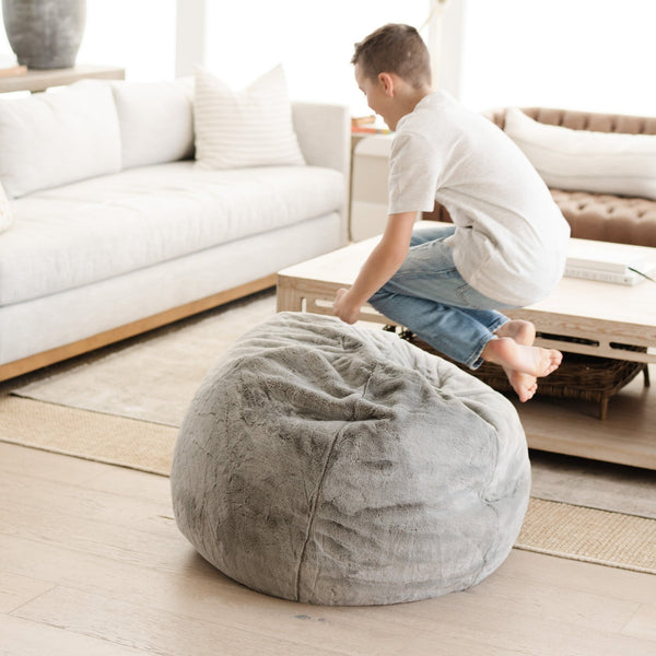 Child playing comfortably on a Saranoni Bean Bag, in a childs playroom.