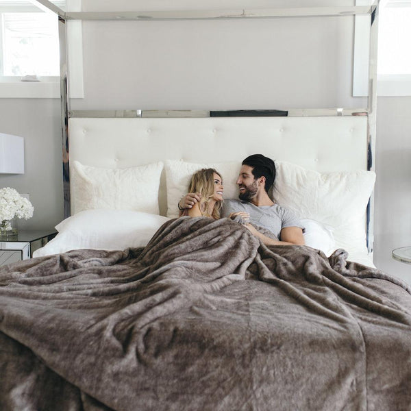 Couple relaxing with a Saranoni blanket, highlighting its softness and warmth.