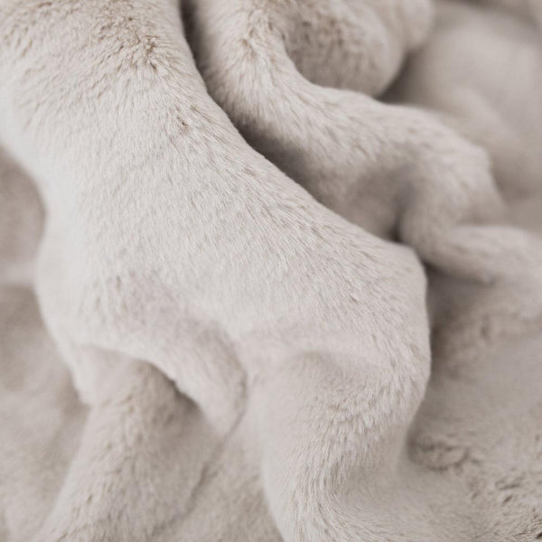 Saranoni blanket displayed on a bed, highlighting its fluffy texture.