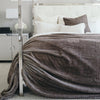 Saranoni Grand blanket used as an accent piece in a stylish bedroom.