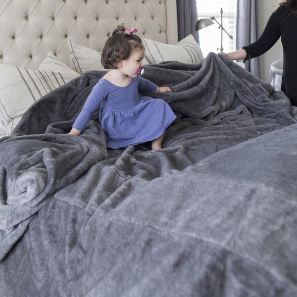 King-sized bed covered with a silky soft Saranoni Grand blanket.