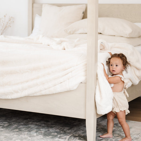 Queen-sized Saranoni blanket draped over bed.