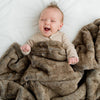 Saranoni faux fur Grand blanket keeping a baby cozy and comfortable.