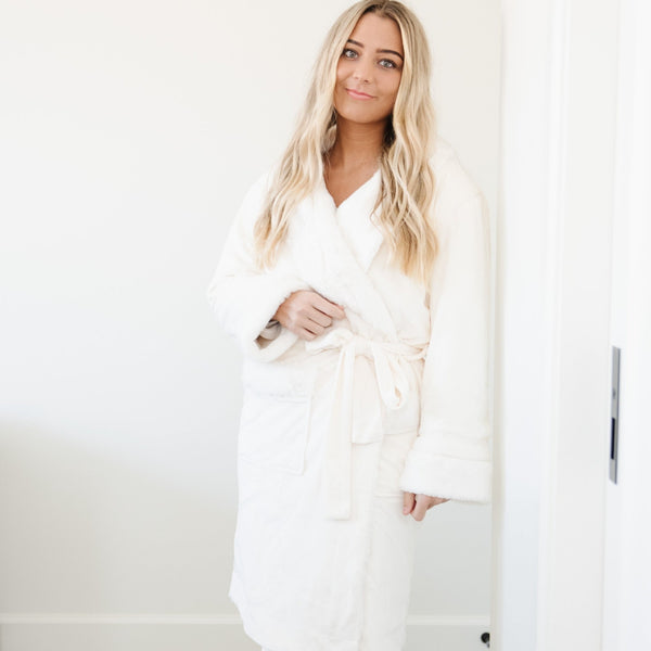 GRAND FAUX FUR ROBES - Woman standing in a luxurious bedroom, wrapped in a Saranoni robe