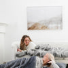 GRAND FAUX FUR SLEEPING BAGS - Two girls lounging in their large gray mink sleeping bags, showcasing luxurious softness.