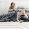 GRAND FAUX FUR SLEEPING BAGS - Girls lying in gray mink sleeping bags, enjoying the cozy feel.