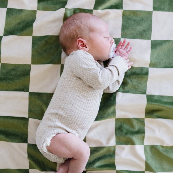 Baby falling asleep on Olive checkered MINKY STRETCH RECEIVING BLANKETS - Saranoni