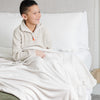 Boy smiling in bed with feather MINKY STRETCH RECEIVING BLANKETS - Saranoni