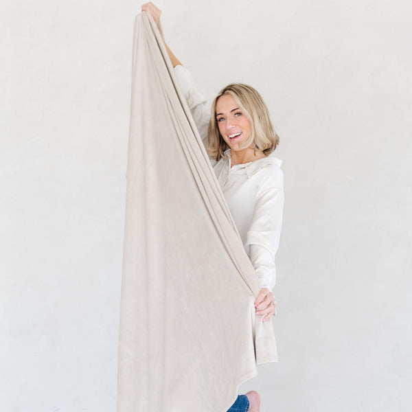 Girl smiling while holding stretchy MINKY STRETCH THROW BLANKETS - Saranoni