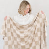 Girl looking at neutral checkered MINKY STRETCH THROW BLANKETS - Saranoni