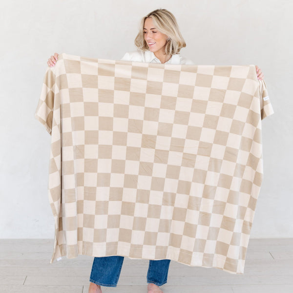 Girl holding out checkered MINKY STRETCH THROW BLANKETS - Saranoni