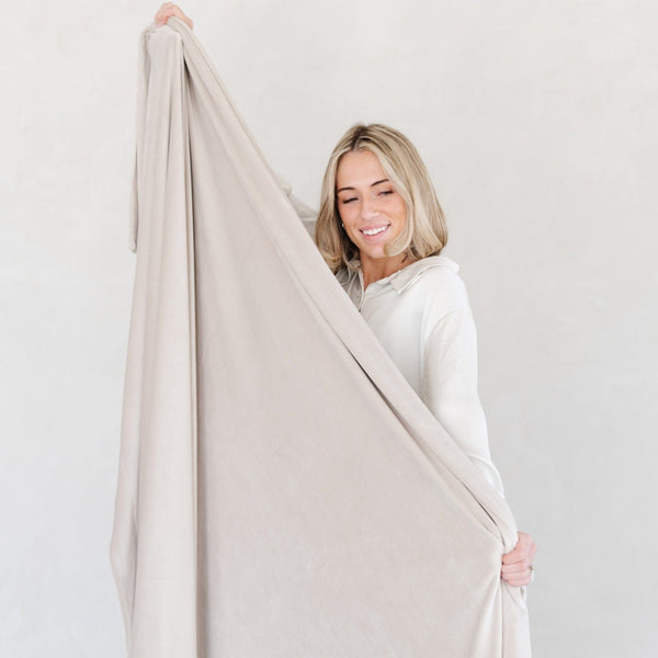 Woman stretching out beautiful grey MINKY STRETCH XL THROW BLANKETS - Saranoni