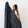 PATTERNED FAUX FUR THROW BLANKETS - Woman feeling the softness of a Saranoni throw blanket