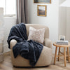 A charcoal luxurious patterned faux fur throw blanket that is a Saranoni blanket is draped over a chair. This ultra-soft, plush throw blanket adds a touch of elegance and warmth to any space, perfect as a soft throw blanket or fluffy blanket for lounging. Ideal for those seeking a high-quality artificial fur blanket or luxury blanket, this versatile and stylish soft blanket enhances both comfort and decor. Shop the best blankets and throws for ultimate relaxation and cozy vibes.