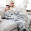 PATTERNED FAUX FUR THROW BLANKETS - Mom and son snuggling with a big fluffy Saranoni blanket.