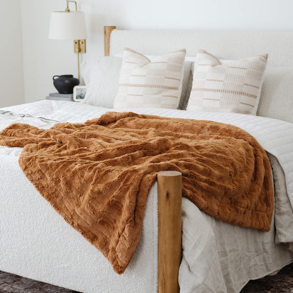 PATTERNED FAUX FUR THROW BLANKETS - Saranoni blanket draped over a chic bed