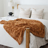 PATTERNED FAUX FUR THROW BLANKETS - Saranoni blanket draped over a chic bed