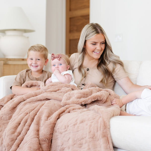 PATTERNED FAUX FUR XL THROW BLANKETS - Mother and child snuggled in a Saranoni blanket, enjoying its comforting feel.