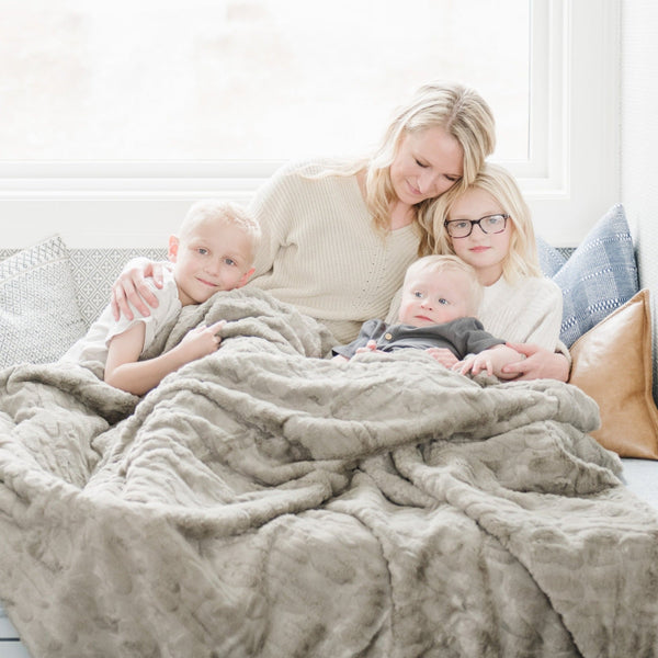 PATTERNED FAUX FUR XL THROW BLANKETS - Comfy and fluffy Saranoni blanket draped over a chair, perfect for warmth.