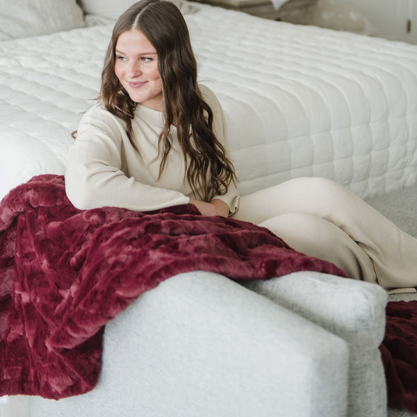 PATTERNED FAUX FUR XL THROW BLANKETS - Girl enjoying a Saranoni blanket, feeling its fluffy softness.