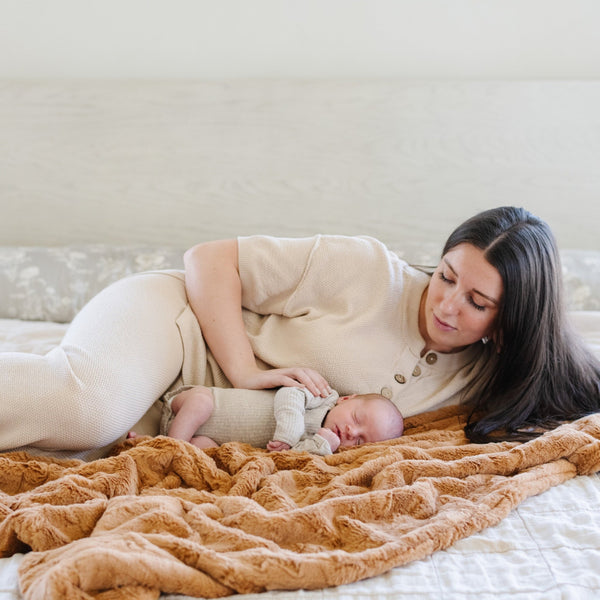 PATTERNED FAUX FUR XL THROW BLANKETS - Fluffy and comfy Saranoni throw blanket on a bed, showcasing its high-quality construction.