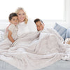 PATTERNED FAUX FUR XL THROW BLANKETS - Big fluffy Saranoni blanket draped over a couch, perfect for comfort and warmth.