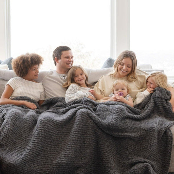 Family laughing together with beautiful and cozy Charcoal RIBBED BAMBONI KING BLANKETS - Saranoni