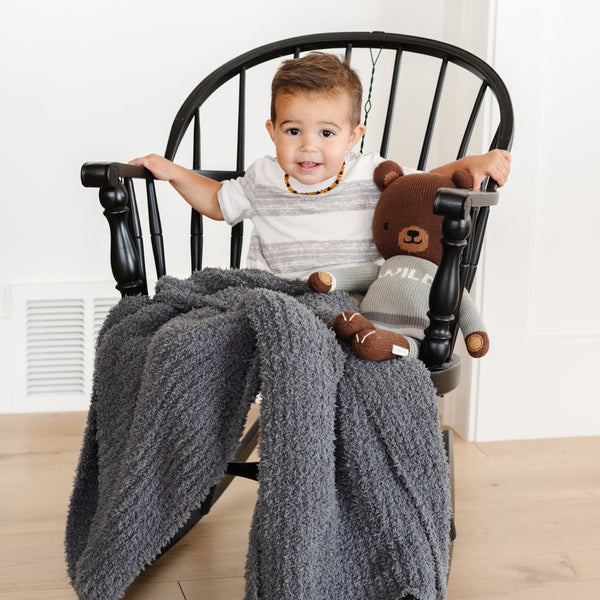 Little boy in rocking chair, wrapped in super soft and comfy Charcoal RIBBED BAMBONI RECEIVING BLANKETS - Saranoni