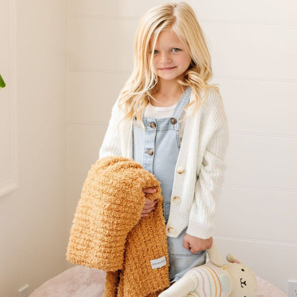 Little girl holding stuffed animal and her favorite Yellow Golden RIBBED BAMBONI RECEIVING BLANKETS - Saranoni