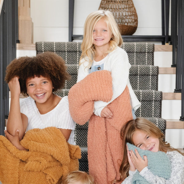 Little girls playing on the stairs with their super soft and comfy RIBBED BAMBONI TODDLER BLANKETS - Saranoni