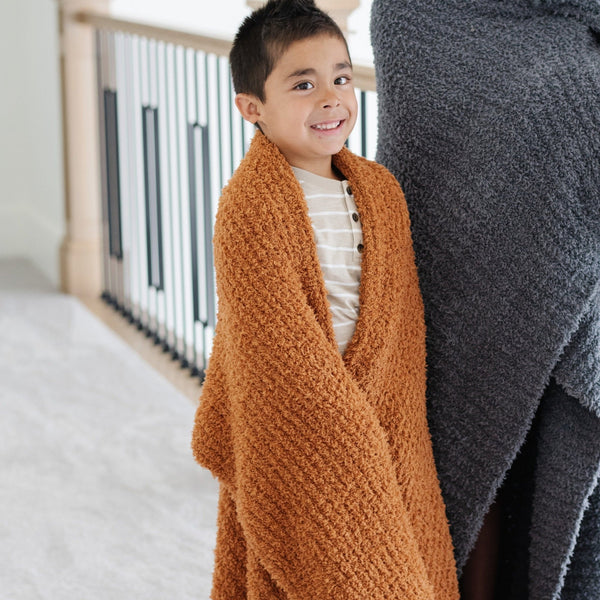 Little boy wrapped in beautiful, extra stretchy soft burn orange Ginger RIBBED BAMBONI TODDLER BLANKETS - Saranoni