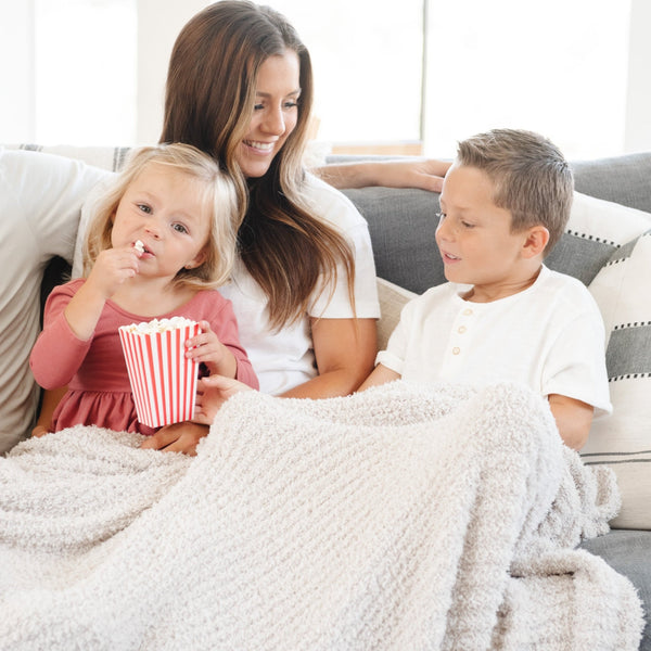 Family snuggled together for movie night, wrapped in soft and warm light gray Moonbeam RIBBED BAMBONI XL BLANKETS - Saranoni